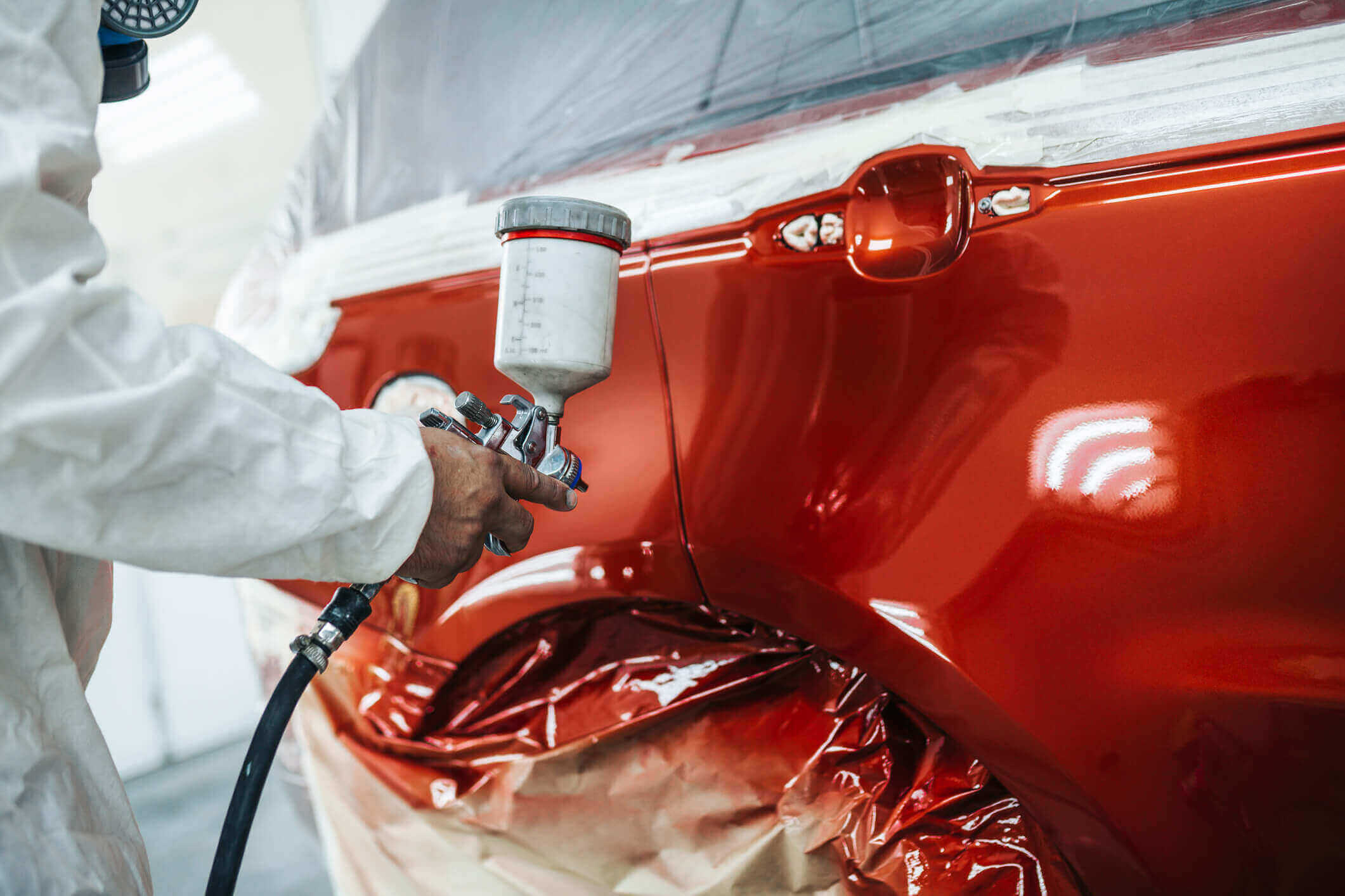 person polishing vehicle with red paint