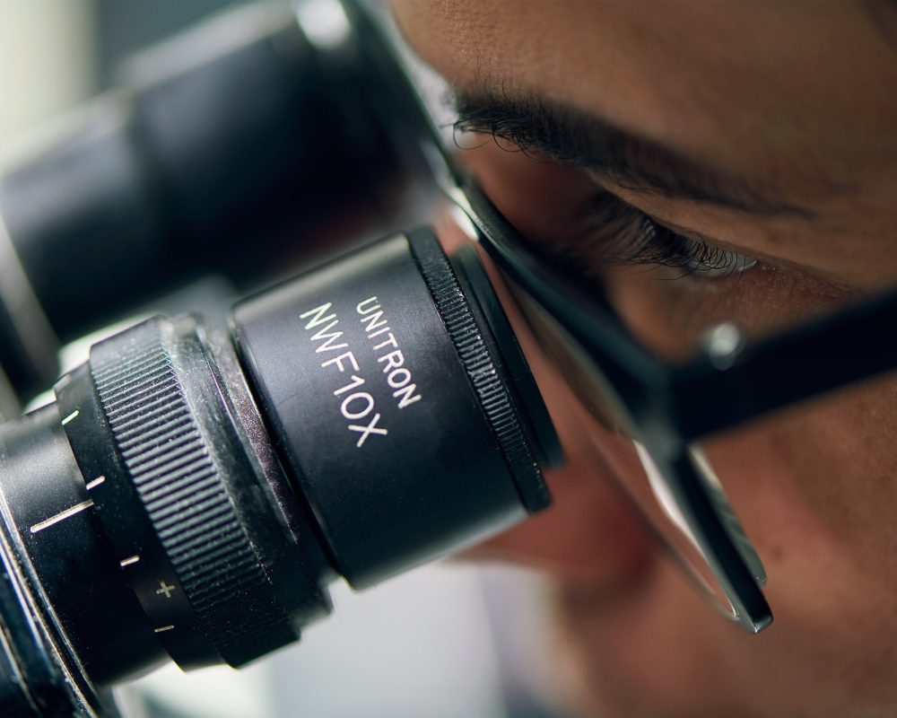 An employee quality checking a metal finished part